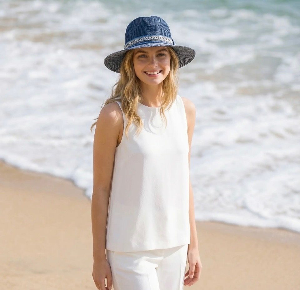 Woman on a beach wearing the Jewelled Band Panama Foldable Hat in navy blue